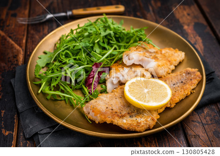 Roasted Pollock fish fillet on a plate with salad. wooden background. top view Roasted Pollock fish fillet on a plate with salad. wooden background. top view 130805428