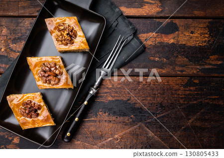 Homemade Walnut Baklava with honey on plate. wooden background. top view 130805433
