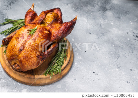 Baked whole duck with apples on wooden board. grey background. top view 130805455