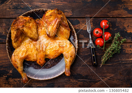 Baked chicken Tabaka Tobacco with spices, poultry meat on plate. wooden background. top view Baked chicken Tabaka Tobacco with spices, poultry meat on plate. wooden background. top view 130805482
