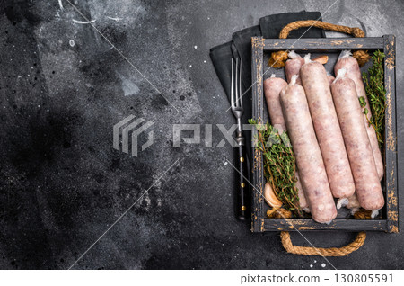 Raw Sausages with minced chicken and turkey meat with herbs in wooden tray. black background. top view Raw Sausages with minced chicken and turkey meat with herbs in wooden tray. black background. top view 130805591