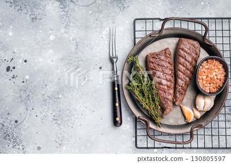 Grilled Mutton tenderloin fillet steak, lamb meat with herbs. grey background. top view Grilled Mutton tenderloin fillet steak, lamb meat with herbs. grey background. top view 130805597