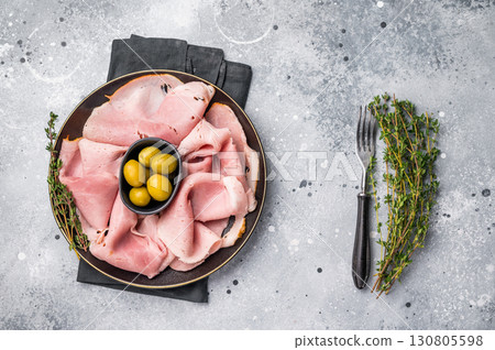 Meat appetizer with Sliced Prosciutto Cotto ham and green olives. grey background. top view 130805598