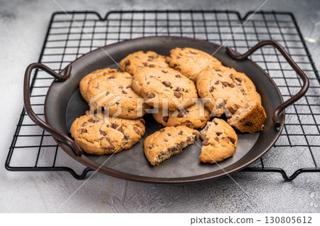 Freshly baked Chocolate chip cookies in steel tray. grey background. top view Freshly baked Chocolate chip cookies in steel tray. grey background. top view 130805612