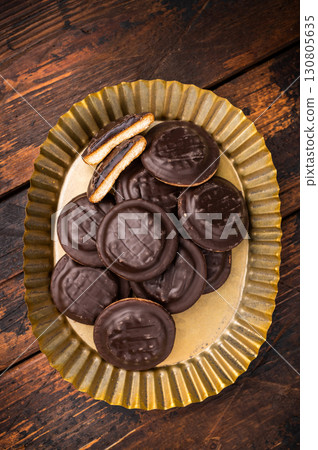 Steel plate with Jaffa Cookies covered with chocolate and filled with jam. Wooden background. top view Steel plate with Jaffa Cookies covered with chocolate and filled with jam. Wooden background. top view 130805635