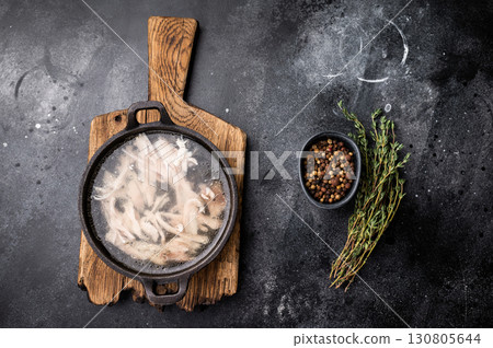 Chicken broth with meat, chicken soup in a skillet. black background. top view 130805644