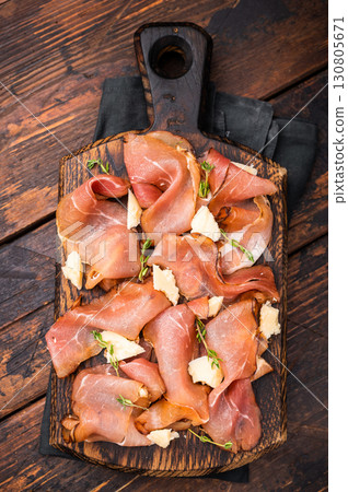 Italian Prosciutto parma ham with herbs and parmesan cheese on wooden board. wooden background. top view 130805671