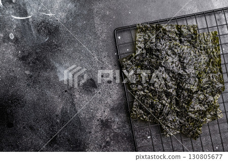 Dried Nori seaweed sheets on a rack. black background. top view Dried Nori seaweed sheets on a rack. black background. top view 130805677