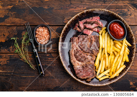 Dinner with grilled Chuck eye roll steak and french fry on a plate. wooden background. top view 130805684
