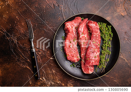 Tri tip steaks, Raw marbled beef meat on plate with herbs. brown background. top view Tri tip steaks, Raw marbled beef meat on plate with herbs. brown background. top view 130805690