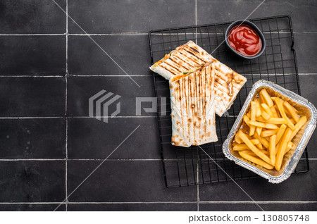 Turkish Shawarma, doner wrap sandwich with meat and salad. black background. top view Turkish Shawarma, doner wrap sandwich with meat and salad. black background. top view 130805748