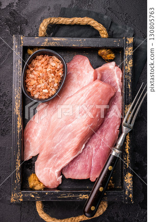 Raw pork chop fillet steaks in a wooden tray. black background. top view Raw pork chop fillet steaks in a wooden tray. black background. top view 130805763