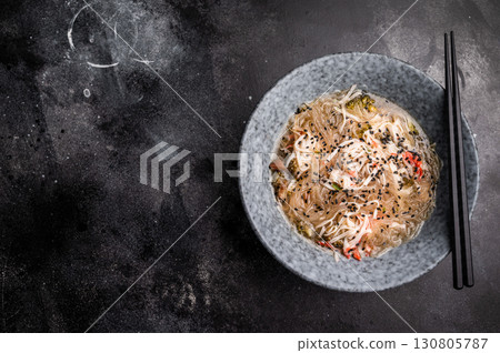 Wok with glass noodles, spicy peanut dressing, meat and vegetables. black background. top view 130805787