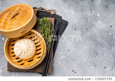 Chinese Bao or Baozi bun with meat in bamboo steamer. grey background. top view 130805795