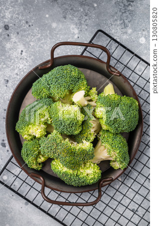 Green fresh broccoli pieces in a steel tray. grey background. top view 130805820