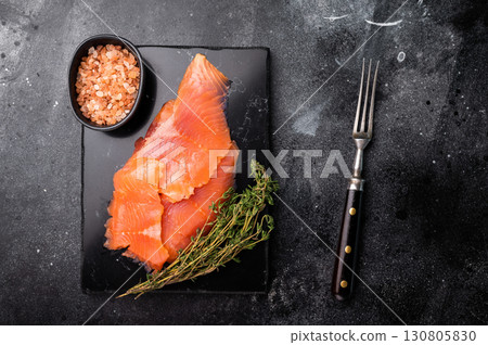 Salted salmon fillet slices on marble board. black background. top view Salted salmon fillet slices on marble board. black background. top view 130805830