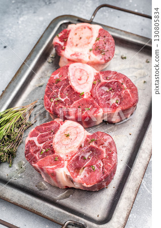 Raw ossobuco cuts, veal shank meat, the ultimate ingredient for rich stews and classic Italian comfort food delights. grey background. top view 130805834