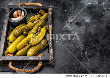 Sweet and tangy pickled cucumbers, ideal for enhancing burgers and wraps with a burst of flavor. black background. top view Sweet and tangy pickled cucumbers, ideal for enhancing burgers and wraps with a burst of flavor. black background. top view 130805851