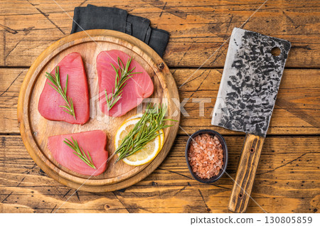 High quality raw tuna steak loin, perfect for a refreshing poke bowl or a delicious seared dish that impresses every time. wooden background. top view High quality raw tuna steak loin, perfect for a refreshing poke bowl or a delicious seared dish that impresses every time. wooden background. top view 130805859
