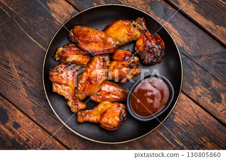 Deliciously sticky teriyakis sauce chicken wings, bursting with flavor, perfect for sharing at festive occasions or family dinners. wooden background. top view 130805860