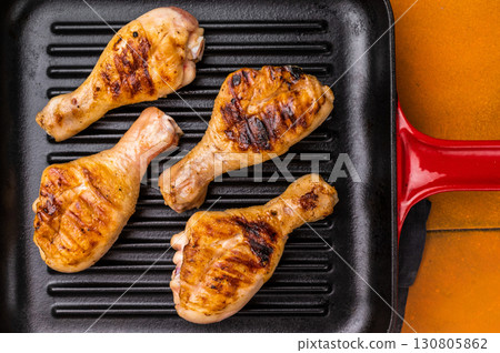 Succulent grilled drumsticks, marinated to perfection and served hot off the grill for a delightful dining experience. orange background. top view Succulent grilled drumsticks, marinated to perfection and served hot off the grill for a delightful dining experience. orange background. top view 130805862