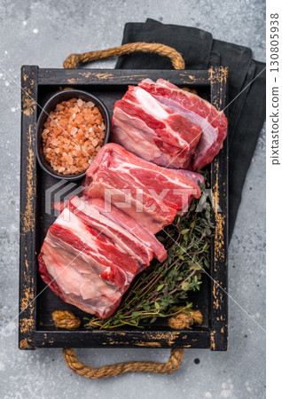 Fresh Raw lamb rib cuts, mutton meat with rib bone in wooden board. grey background. top view Fresh Raw lamb rib cuts, mutton meat with rib bone in wooden board. grey background. top view 130805938