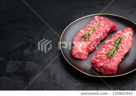 High-quality Denver cut, featuring a perfect balance of fat and meat steak. A great choice for those seeking a flavorful and juicy steak experience. black background. top view High-quality Denver cut, featuring a perfect balance of fat and meat steak. A great choice for those seeking a flavorful and juicy steak experience. black background. top view 130805942