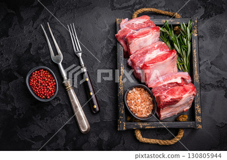 Raw Veal Short Rib, fresh beef meat with bone and herbs for cooking . black background. top view Raw Veal Short Rib, fresh beef meat with bone and herbs for cooking . black background. top view 130805944