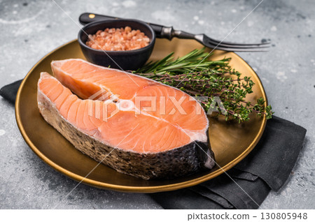 Juicy raw salmon cut, highlighting its natural marbling and freshness. Perfect for grilling or baking to create a mouthwatering meal. grey background. top view Juicy raw salmon cut, highlighting its natural marbling and freshness. Perfect for grilling or baking to create a mouthwatering meal. grey background. top view 130805948