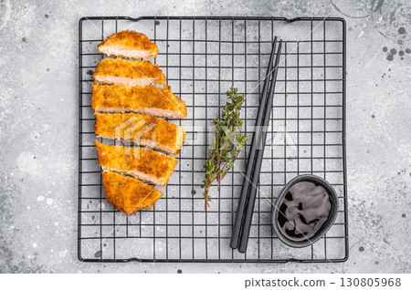 Tender chicken cutlet katsu, coated in crunchy breadcrumbs and fried to perfection. Ideal for a satisfying meal or as a topping for rice. grey background. top view 130805968