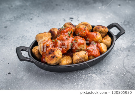 Roast meatballs served with tomato sauce. A classic comfort food in a skillet. grey background. top view 130805980