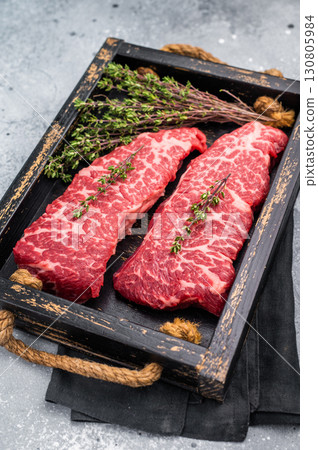 Exquisite beef shoulder tender, denver steak waiting to be transformed into a gourmet dish. Ideal for grilling or roasting for an unforgettable dinner. grey background. top view Exquisite beef shoulder tender, denver steak waiting to be transformed into a gourmet dish. Ideal for grilling or roasting for an unforgettable dinner. grey background. top view 130805984