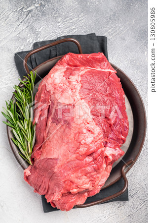 Beautifully arranged raw boneless beef shank pieces on a rustic platter, inviting creativity in the kitchen for delicious slow-cooked meals. grey background. top view Beautifully arranged raw boneless beef shank pieces on a rustic platter, inviting creativity in the kitchen for delicious slow-cooked meals. grey background. top view 130805986