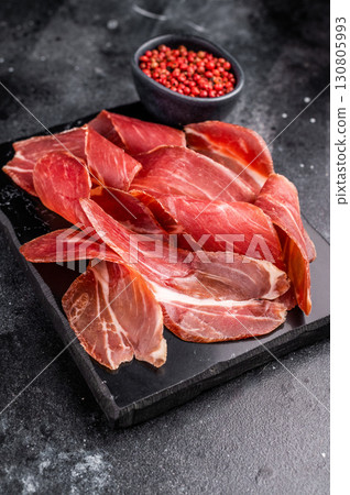 Sliced prsut prshut, Balkan cured pork meat ham. black background. top view Sliced prsut prshut, Balkan cured pork meat ham. black background. top view 130805993