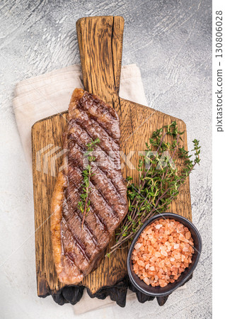 Grilled Top Sirloin, cooked rump beef steak. grey background. top view 130806028