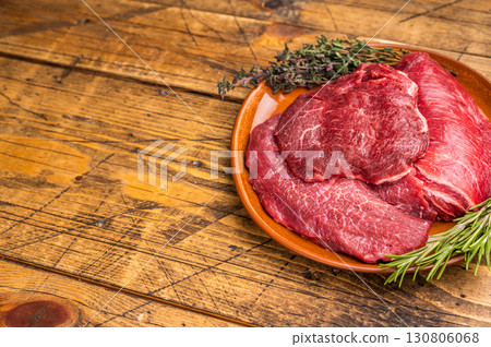 Traditional German beef cheeks, raw meat in plate. wooden background. top view 130806068