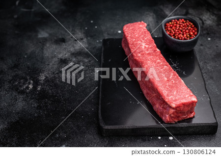 Exquisite raw wagyu beef, showcasing its rich marbling and vibrant color, perfect for gourmet dishes or high-end grilling experiences. black background. top view 130806124