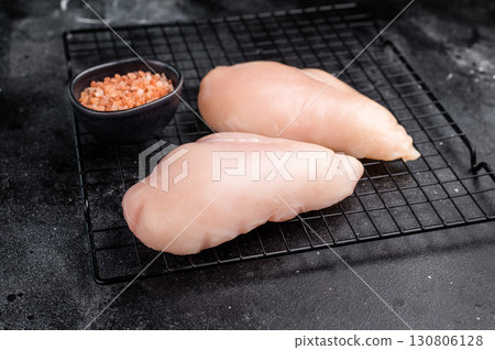 Fresh chicken breasts, beautifully displayed, showcasing their tender texture. Perfect for marinating and cooking your favorite dishes. black background. top view 130806128