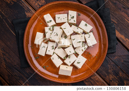 Uncooked Diced soybean tofu cheese on plate. wooden background. top view Uncooked Diced soybean tofu cheese on plate. wooden background. top view 130806158