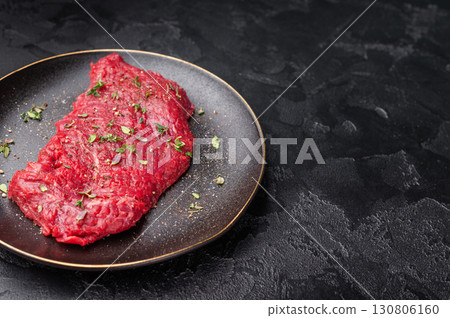 Marinated Flank or Flap steak, raw beef meat with thyme and spices on plate. black background. top view 130806160