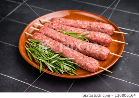 Raw Cevapcici skewers, Cevapi sausages from mince beef and pork meat. black background. top view Raw Cevapcici skewers, Cevapi sausages from mince beef and pork meat. black background. top view 130806164
