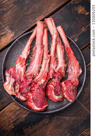 Raw lamb chop cutlets, fresh mutton meat for steaks with herbs. wooden background. top view Raw lamb chop cutlets, fresh mutton meat for steaks with herbs. wooden background. top view 130806205