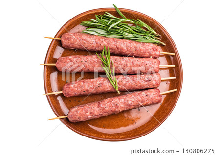 Raw Turkish Urfa kebab skewers on a plate with herbs isolated on white background. top view Raw Turkish Urfa kebab skewers on a plate with herbs isolated on white background. top view 130806275