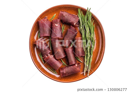 Typical dried spanish meat cecina, spanish beef jamon on plate with rosemary isolated on white background. top view 130806277