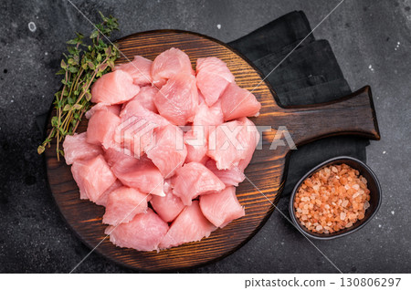 Sliced turkey fillet cubes, diced poultry breast meat. black background. top view Sliced turkey fillet cubes, diced poultry breast meat. black background. top view 130806297