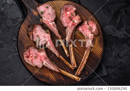 French roast lamb chops, mutton meat steaks on wooden board. black background. top view 130806298