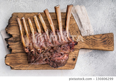 Grilled Rack of lamb, mutton meat chop steaks on wooden board. grey background. top view 130806299