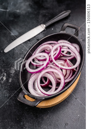 Fresh Raw onion rings in skillet. black background. top view 130806313
