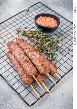 BBQ Roasted beef and lamb meat kebabs sausages, kofta kebab. grey background. top view BBQ Roasted beef and lamb meat kebabs sausages, kofta kebab. grey background. top view 130806315
