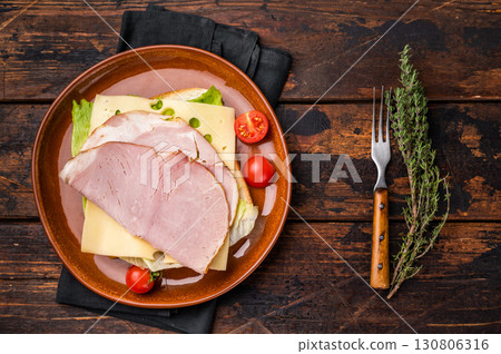 Prosciutto Cotto Ham and cheese sandwich, toast with sliced meat, cheese and salad. wooden background. top view 130806316